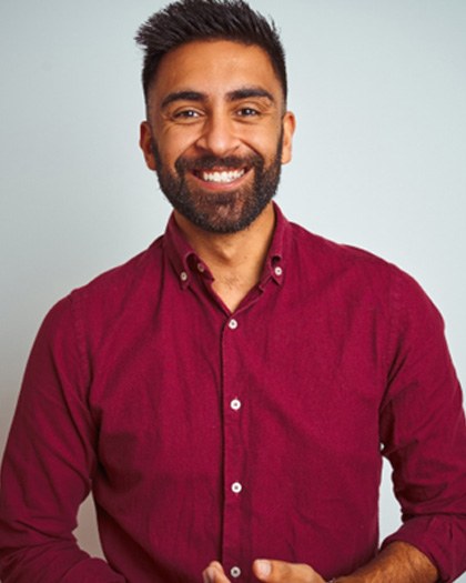 A man wearing a red shirt and smiling with a dental bridge in Westport 