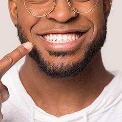 man pointing to his smile after investing in cosmetic dentistry in Westport