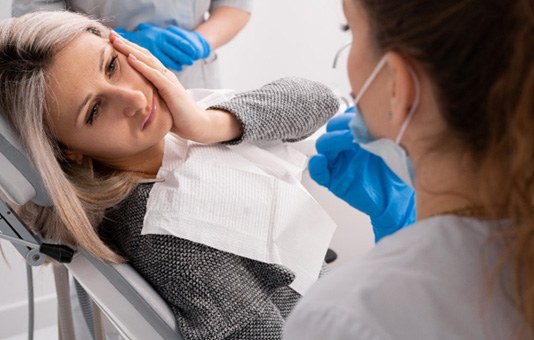 A female patient in pain and needing a dental crown   