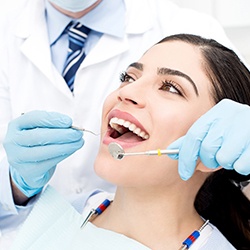 dentist looking at patient’s teeth 