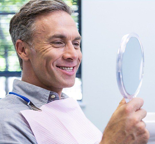 man smiling in circle mirror