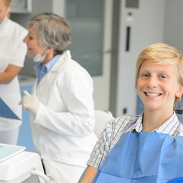 Teenage boy smiling while sitting in treatment chair