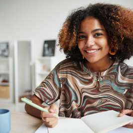 Teen girl smiling while working on homework