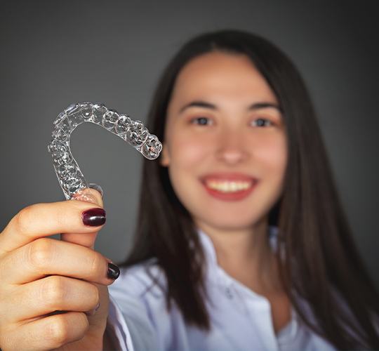 girl holding invisalign