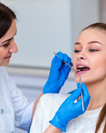 A female patient having her teeth checked by a dental professional