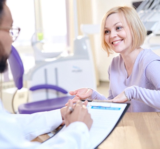 A dentist talking to a female patient 