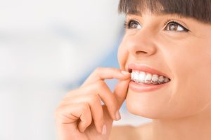 girl putting on Invisalign