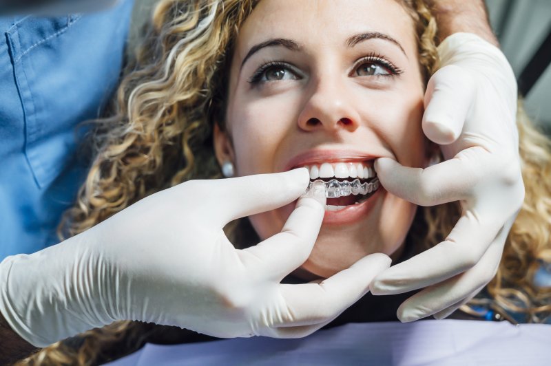 woman receiving Invisalign aligners