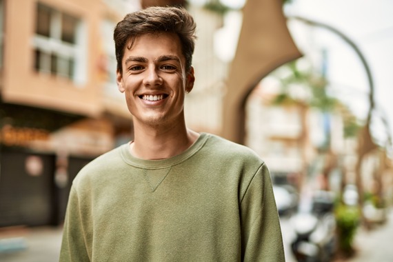 man smiling while standing outside 