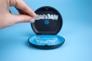 a hand holding an Invisalign tray